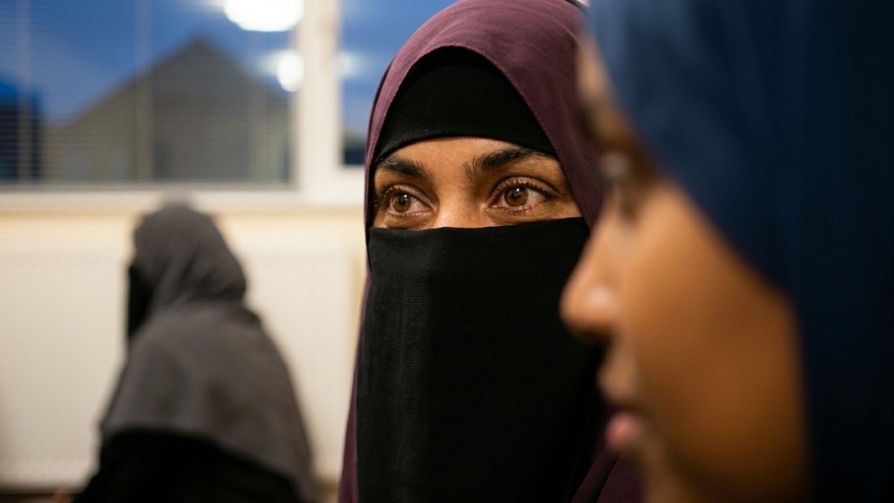 A Muslim woman listens intently during an evening information session.
