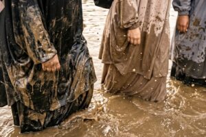A group of Muslim women wade through muddy water during their Trials & Tribulations challenge.