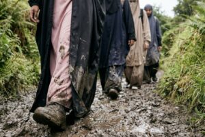 A group of Muslim women wade through muddy water during their Trials & Tribulations challenge.